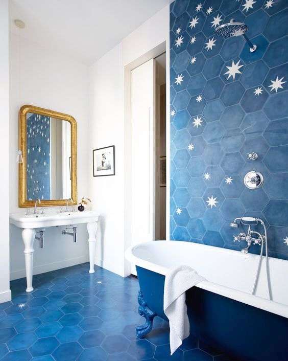 حمامی با کاشی‌های ستاره‌ای و شش گوش آبی پررنگ، وان آبی و سفید