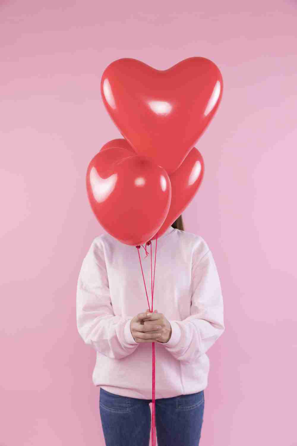 woman holding red balloons min scaled e1643891887559